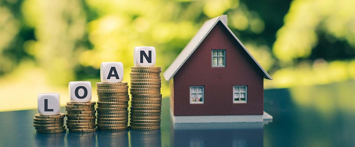House model with loan coins representing home construction finance